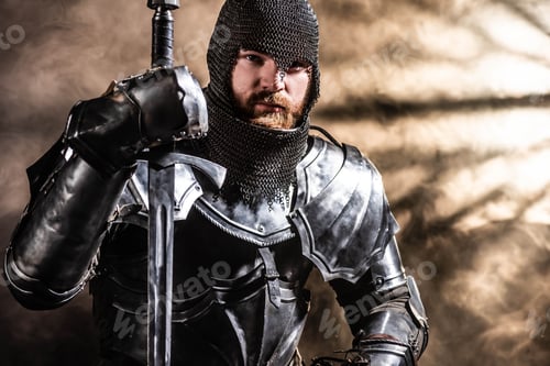Preview: handsome knight in armor holding sword on black background