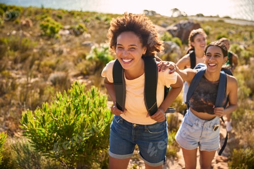 Vista previa: Group Of Female Friends With Backpacks On Vacation On Hike Through Countryside Next To Sea