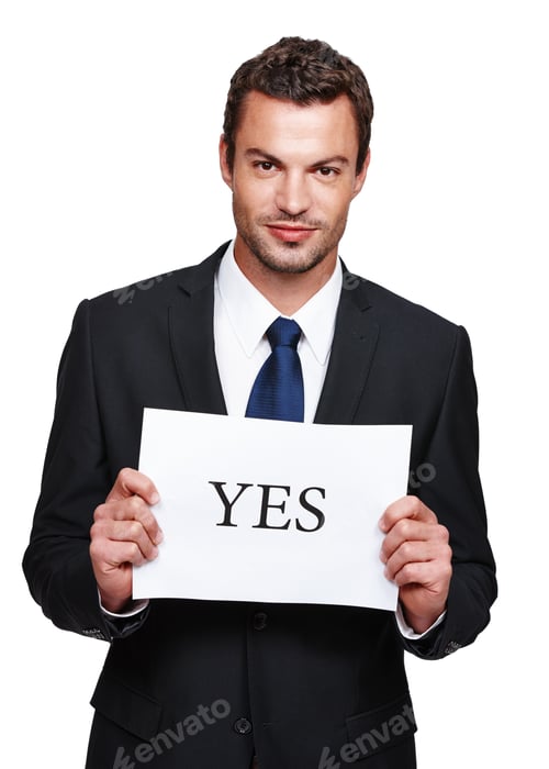 Preview: Always stay positive. A handsome young businessman holding a placard with yes on it.