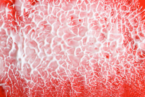 Preview: Creamy texture on a red background, top view