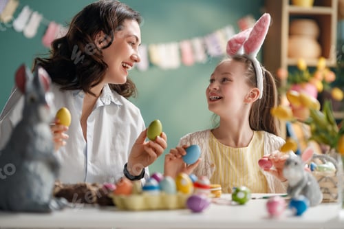 Preview: Happy Mother and Daughter Painting Easter Eggs Together at Home