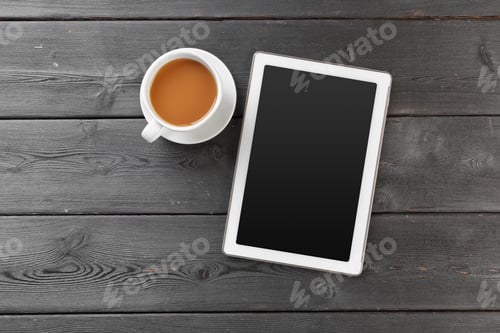 Preview: Digital tablet on wooden table in cafe with cup coffee