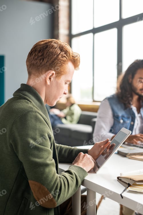 Preview: Young software developer scrolling through sketches of new mobile applications
