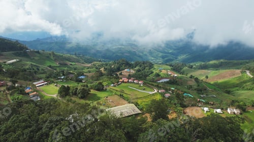 Preview: Aerial view of rural village and mountain road on cloudy day by drone