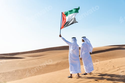 Preview: Two middle-eastern emirati men wearing arab kandura bonding in the desert