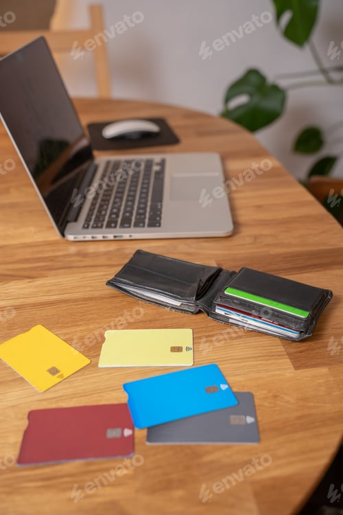 Preview: Credit cards in the wallet laptop open access for online shopping in a modern house