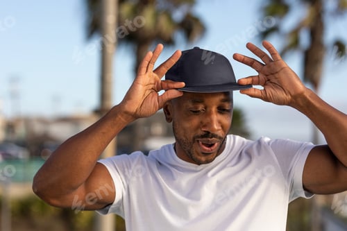 Preview: African American man wearing a cap, tipping hat for swag