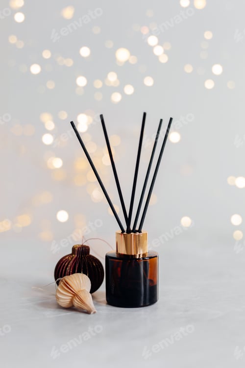 Preview: Home aroma fragrance diffuser and burning candles on wooden table in the bedroom.