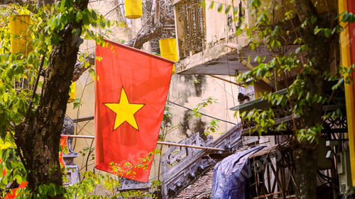 Preview: A red national flag of Vietnam stands above the streets of Hanoi. Symbol country