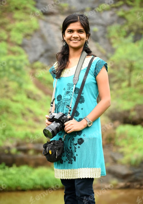 Preview: Beautiful young woman in nature with camera