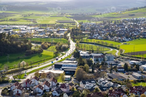 Preview: A town with roads, fields, pastures against the backdrop of silhouettes of hills and a cloudy sky