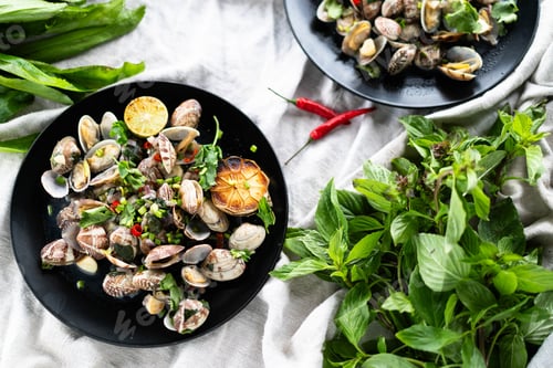 Preview: Delicious seafood feast with clams and mussels garnished with herbs and spices on a green backdrop