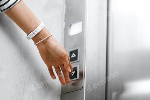 Preview: Female hand pushing the button of elevator