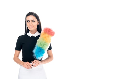 Preview: Brunette maid in uniform holding duster isolated on white