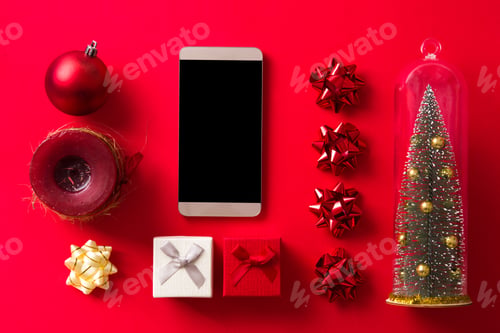 Preview: Christmas shopping online with smartphone, gifts, candle and decorations on red background