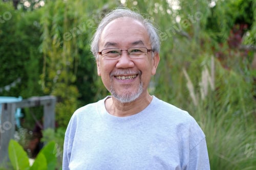 Preview: Portrait of happy senior man looking camera at home