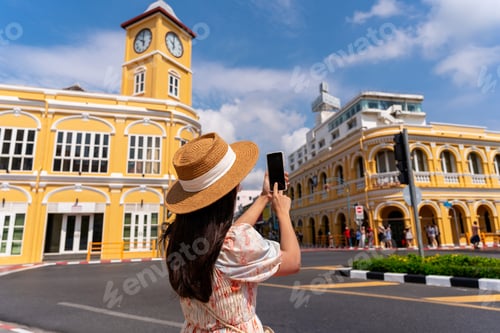 Preview: Young woman traveler walking and taking a photo at Phuket old town in Thailand