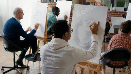 Preview: African american student using pencil to draw vase model on canvas