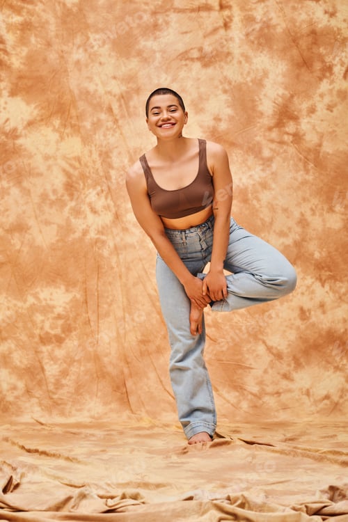 Preview: body positivity and confidence, happy young woman in crop top and jeans posing on mottled beige