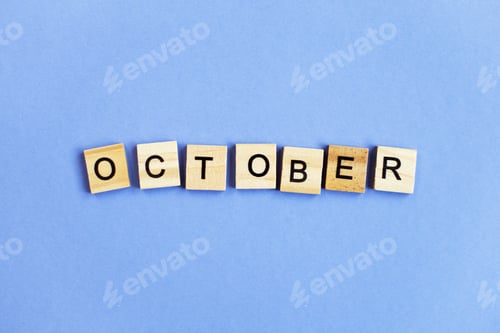 Preview: inscription October made by wooden cubes on a veri peri purple background