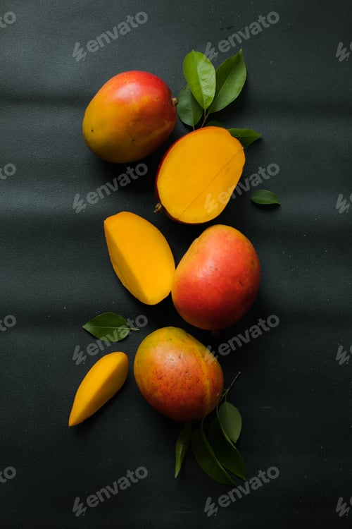 Preview: Mango background design concept. Top view of fresh mango fruit pattern with leaves on table.