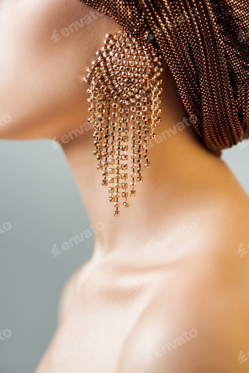 Preview: cropped view of young woman in turban and golden earring isolated on grey