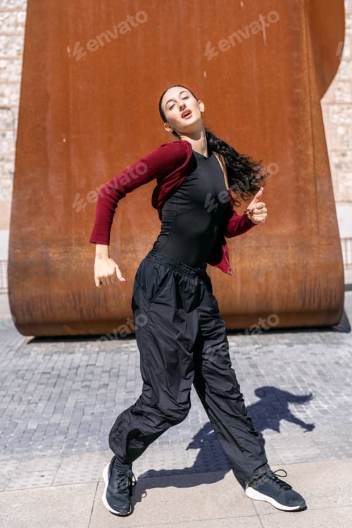 Preview: Young woman dancing hip hop on urban street