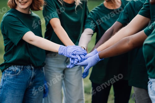 Preview: Volunteers wearing matching shirts and gloves joining hands