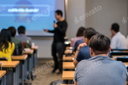 Preview: Rear side of Audiences sitting and listening the speackers on the stage in low light meeting room