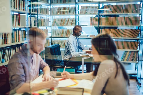 Preview: Black student sitting in library near classmates
