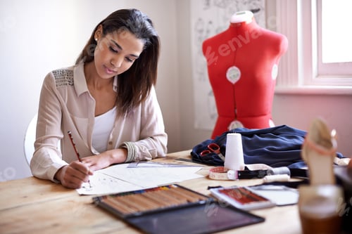 Preview: Creating this seasons trends. A fashion designer creating sketches in her office.