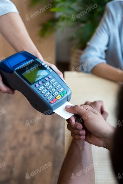 Preview: close-up partial view of payment by credit card and terminal in cafe