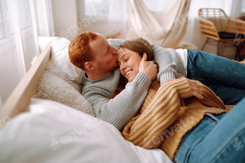 Preview: Couple in love relaxing at home on bed while they hug each other. Valentine's Day, holiday concept.