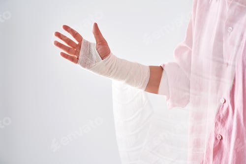 Preview: A woman in a pink shirt holds a bandage and puts a bandage on her arm.