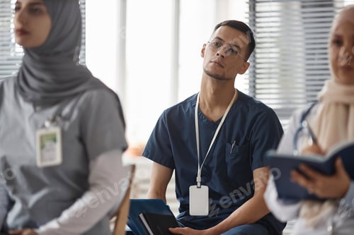 Preview: Male Doctor Listening to Presentation at Medical Conference