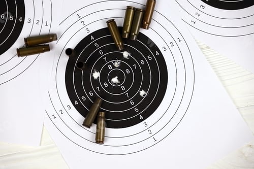 Preview: Many bullets on shooting targets on white table in shooting range polygon