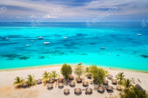 Preview: Aerial view of umbrellas, green palms on the sandy beach