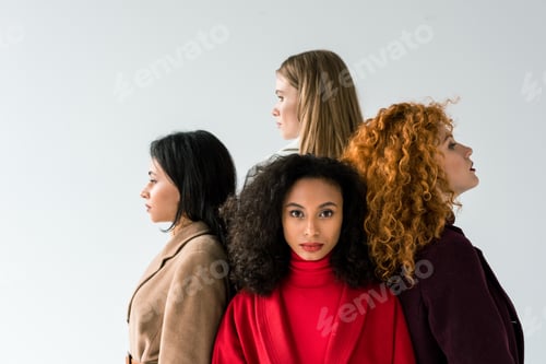 Preview: attractive curly african american girl looking at camera near girls on white