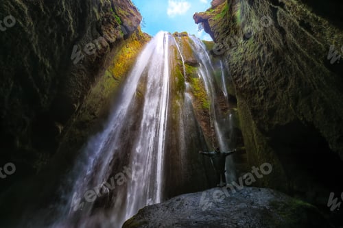Preview: Traveler stunned by Gljufrabui waterfall cascade in Iceland.