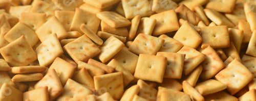 Preview: A lot of small cookies are square shaped. A pattern of a yellow salt cracker