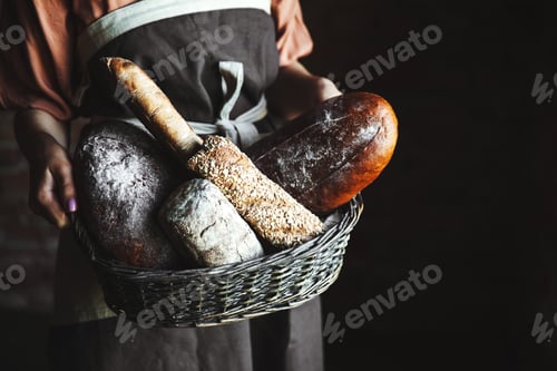 Preview: French baguettes in female hands on a black background. homemade baking