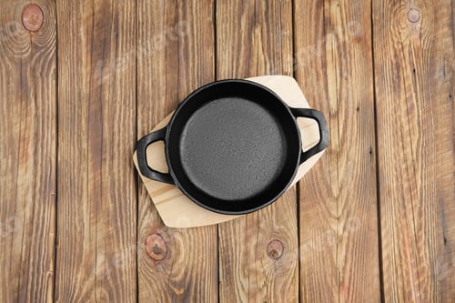 Preview: Top view of cast-iron skillet with two handles on wooden table