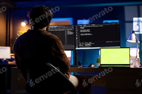 Preview: Developer Coding Late on Multiple Computer Screens