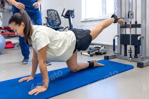 Preview: Woman Exercises Leg With Physical Therapist in Gym