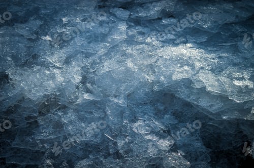 Preview: Broken ice on the surface of water in winter. Dark abstract background