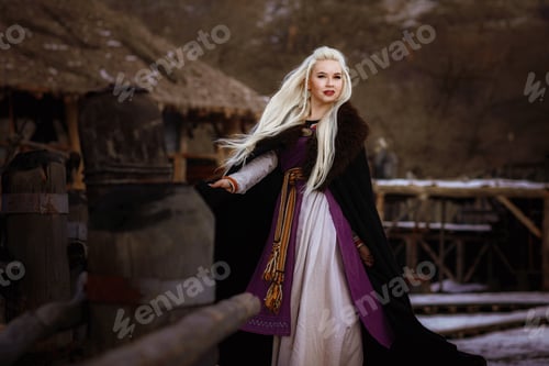 Preview: Beautiful blonde Viking dressed in a black cloak against the backdrop of the castle