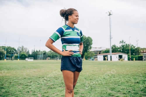 Preview: Confident female rugby player standing on the field