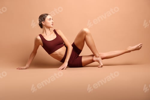 Preview: Woman doing gymnastic exercise on beige background