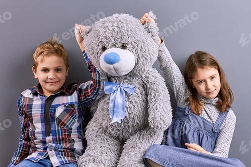 Preview: Two kids sitting with big teddy bear