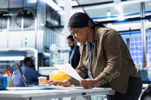 Preview: African american woman specialist reading documents in the manufacturing plant